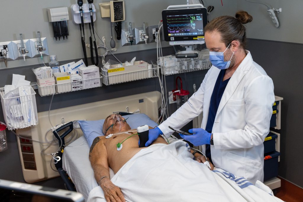 Dr. Oron Frenkel uses the point-of-care ultrasound device on a patient.