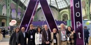 Group photo of Canada’s delegation at the Adopt AI Summit in Paris, standing in front of a large purple “A” installation inside the Grand Palais. Brian Simmers is standing third from the right among the delegation members.